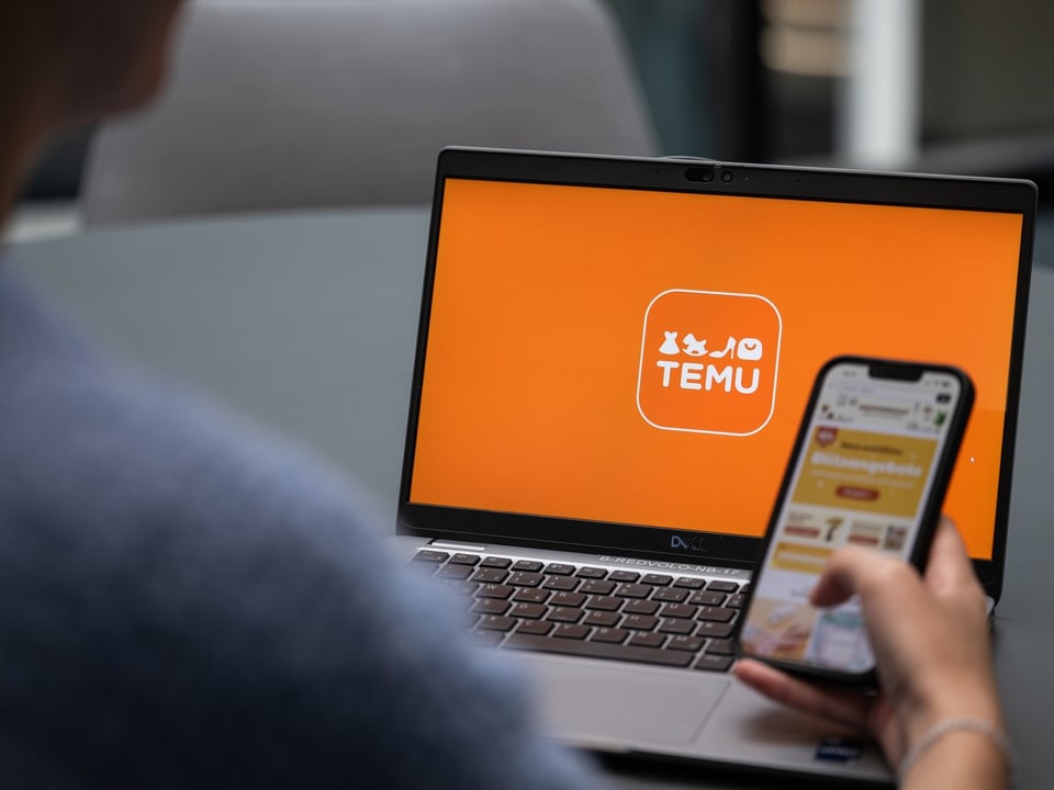 Person betrachtet TEMU-Website auf Laptop und Handy.