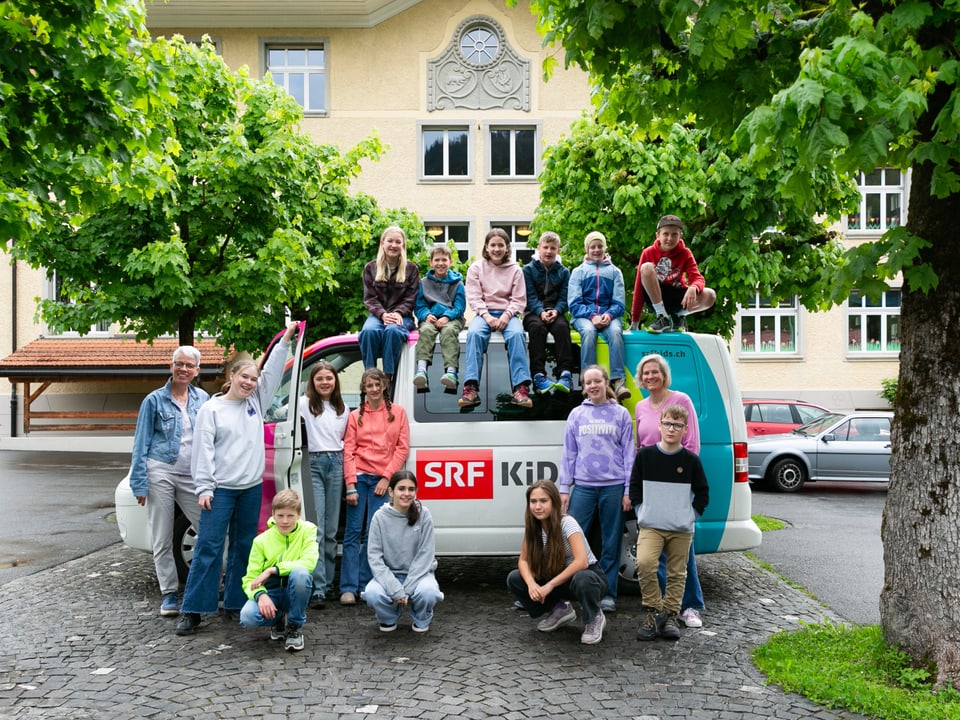 Die 5./6. Klasse aus Gstaad mit dem SRF Kids Bus vor ihrem Schulhaus.