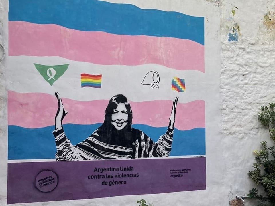 Wandgemälde mit der Aufschrift 'Argentina Unida contra las violencias de género' und einer Frau, die ihre Arme hebt.