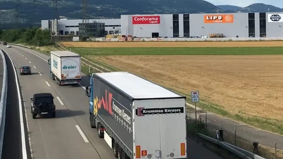 Eine Autobahn und im Hintergrund ein Logistikzentrum.