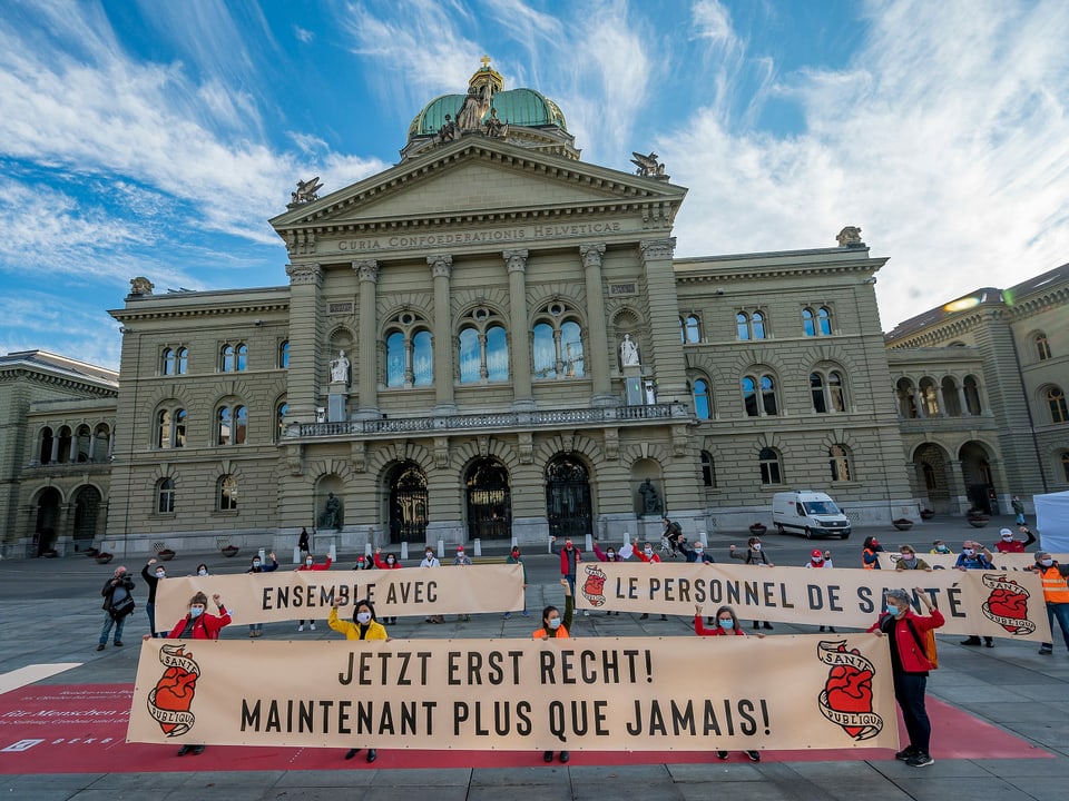 Purtret da la Chasa federala ed ils demonstrants che tegnan si banners. 