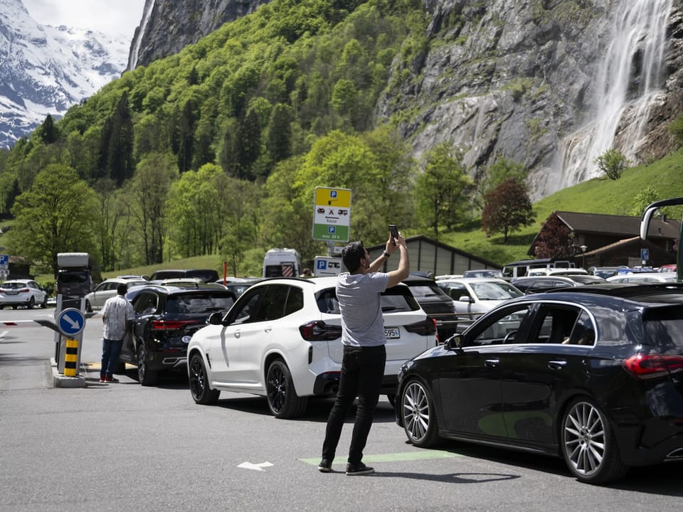 Touristen warten mit ihren Autos auf freie Parkplätze in Lauterbrunnen im Berner Oberland. 