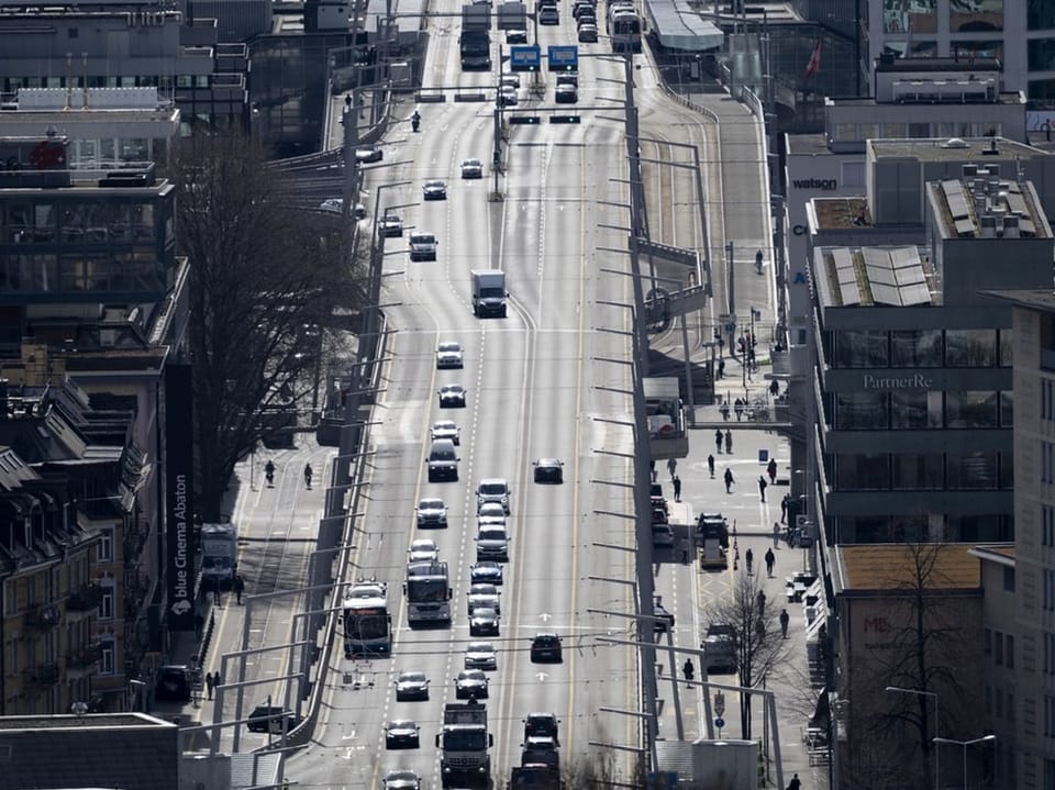 Strassenansicht mit Autos und Fussgängern in der Stadt.