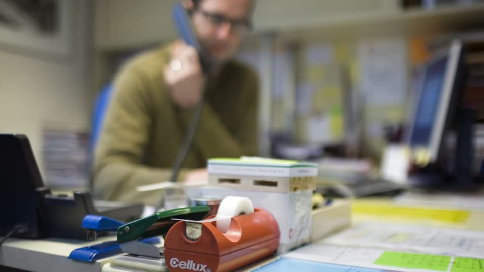 Ein Mann telefoniert an einem Schreibtisch.