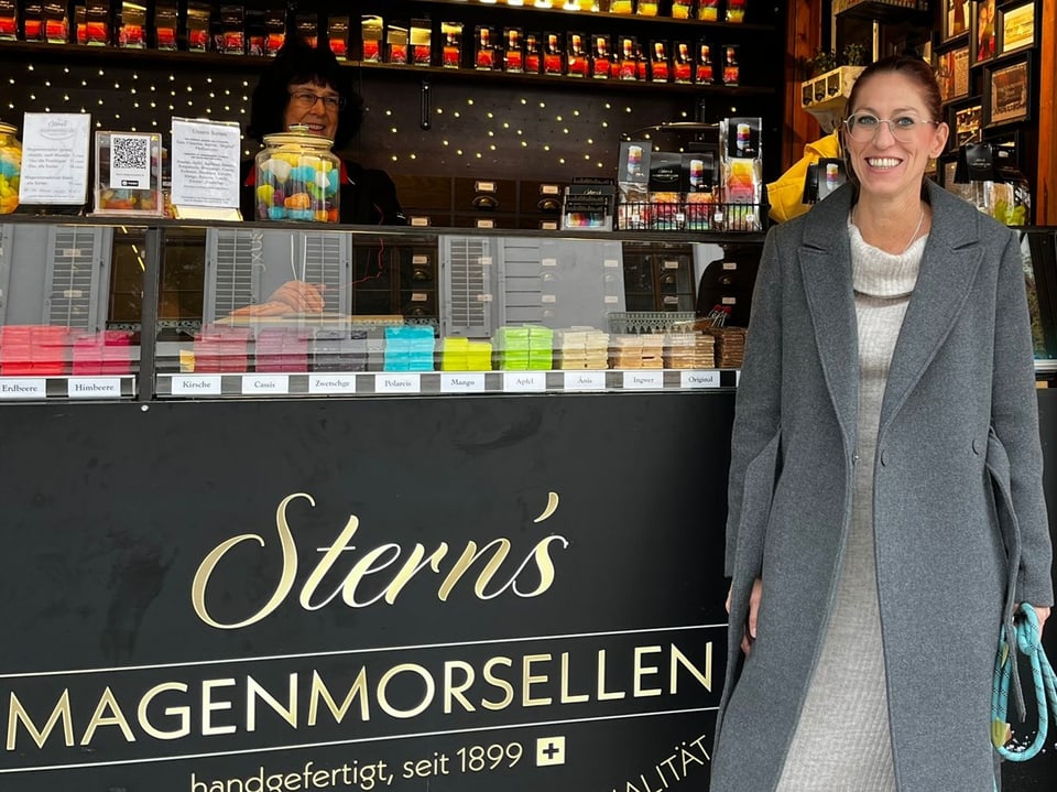 Frau steht vor einem Messestand. 