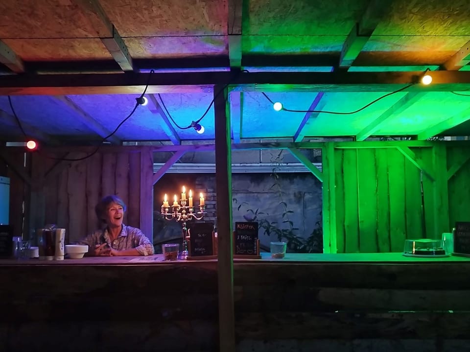 Bar, beleuchtet mit farbigem Licht und Kerzen.