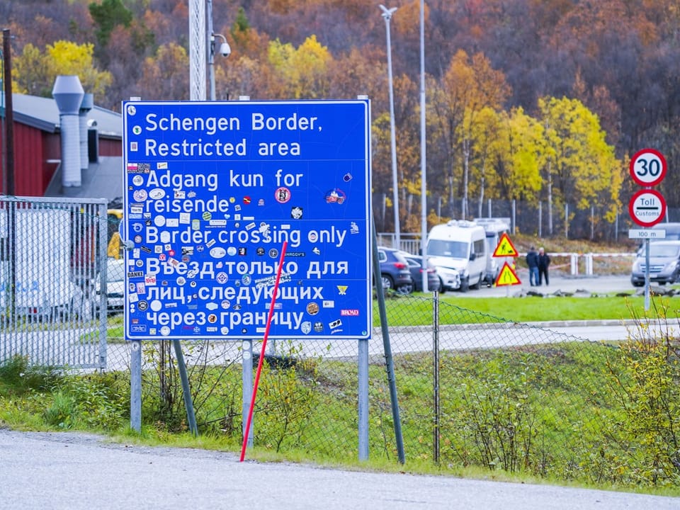 Blaues Schild an der Schengen-Grenze mit Warnungen und Beschränkungen.