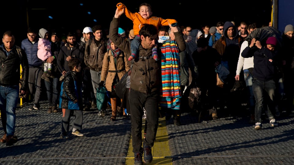 Flüchtlinge verlassen Fähre. 