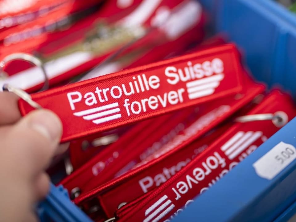 Nahaufnahme eines roten Schlüsselanhängers mit der Aufschrift "Patrouille Suisse forever". 