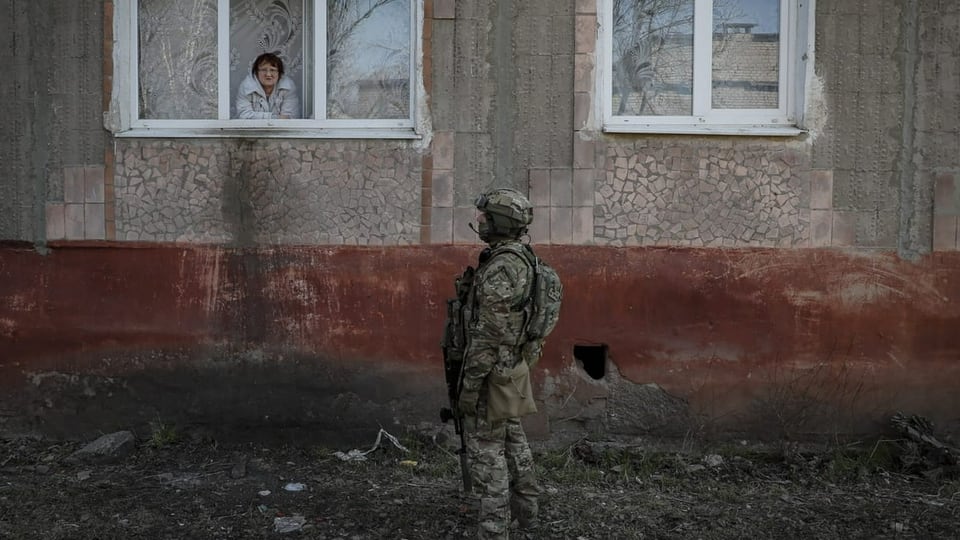 Soldat spricht mit Anwohnerin in Gorlovka,Oblast Donetsk am 26.3.2022