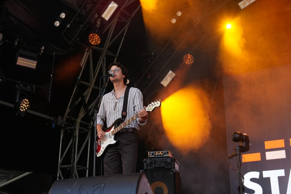 Musiker mit Gitarre auf einer Bühne.