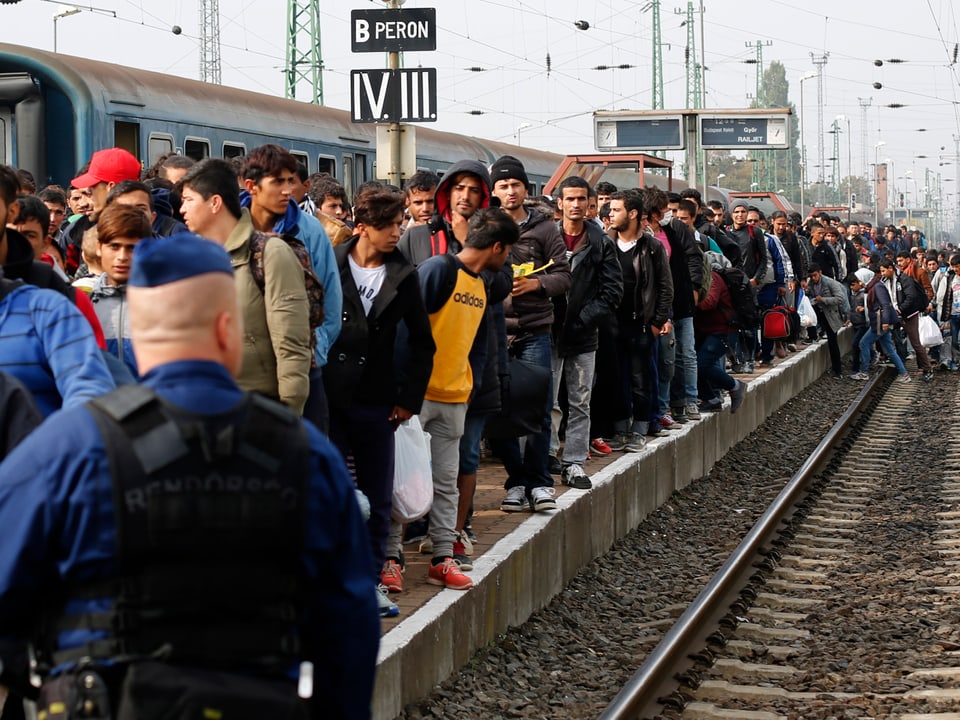 Dutzende Menschen drängen sich auf einem Bahnsteig