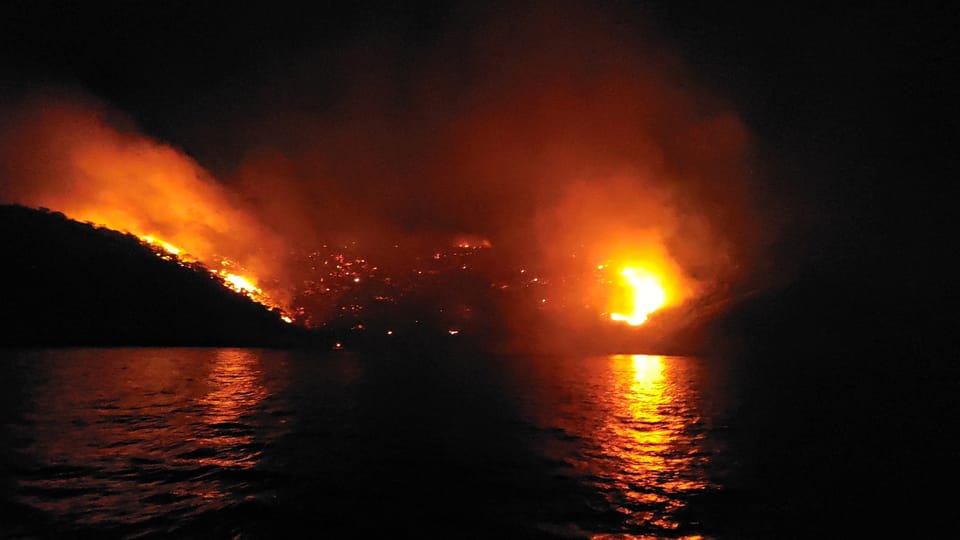 Eine Insel im Dunkeln. Es sind mehrere grosse Feuer zu sehen.