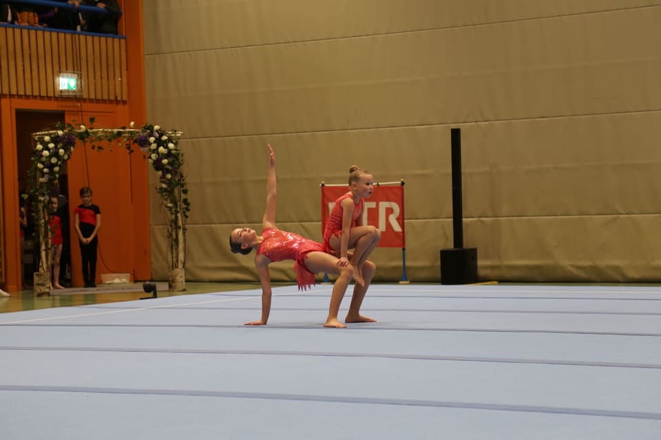 Zwei Mädchen im roten Outfit bei Gymnastikvorführung in Halle.