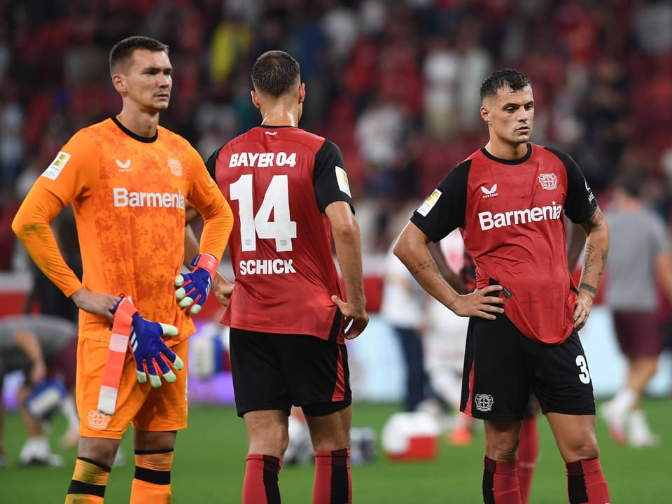 Drei Bayerspieler im Fussballstadion mit Trikots.