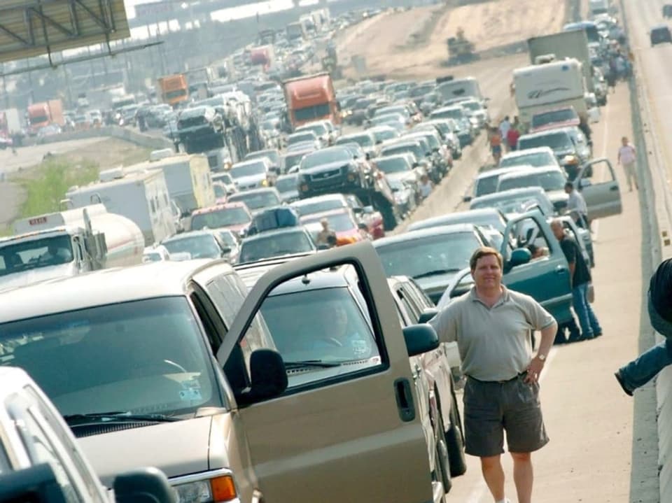 Verkehrsstau auf der Autobahn mit ausgestiegenen Autofahrern.