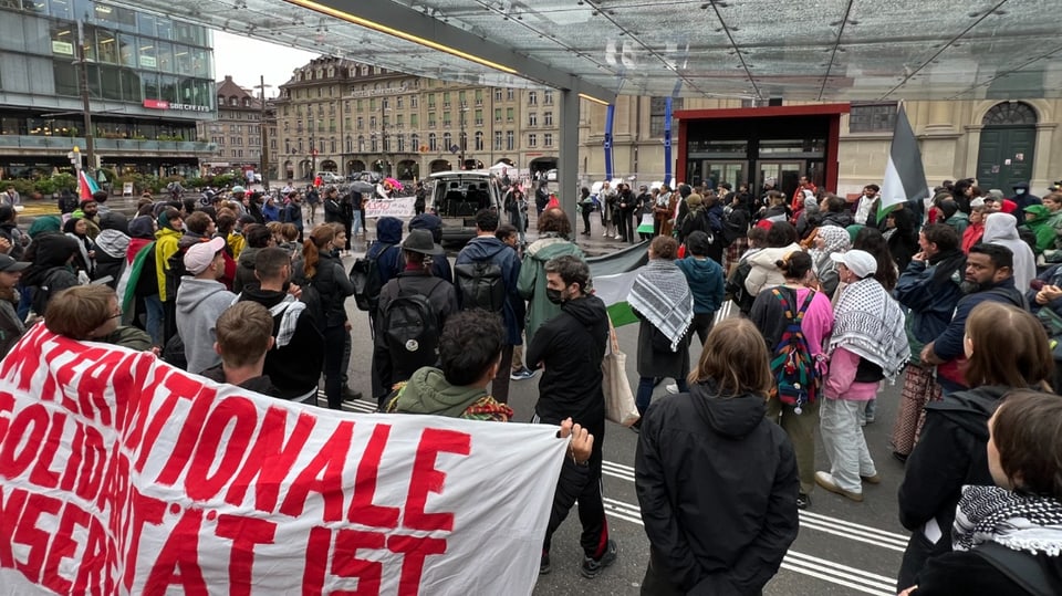 Menschenmenge bei einer Demonstration unter dem Glas-Baldachin  auf dem Bahnhof Bern.