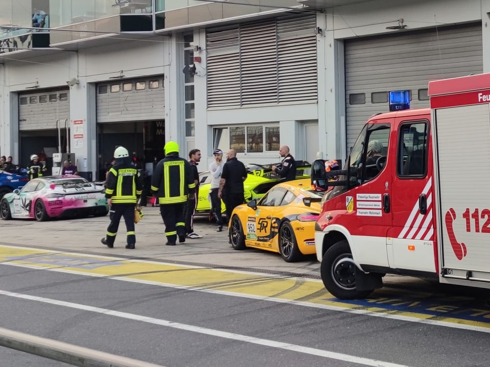 Feuerwehr und Krankenwagen stehen vor dem Fahrerstall am Nürburgring.