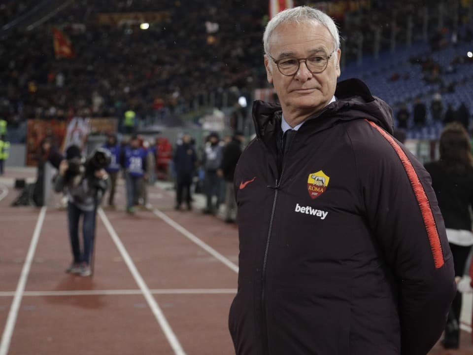 Mann in AS Roma Jacke auf Fussballplatz.