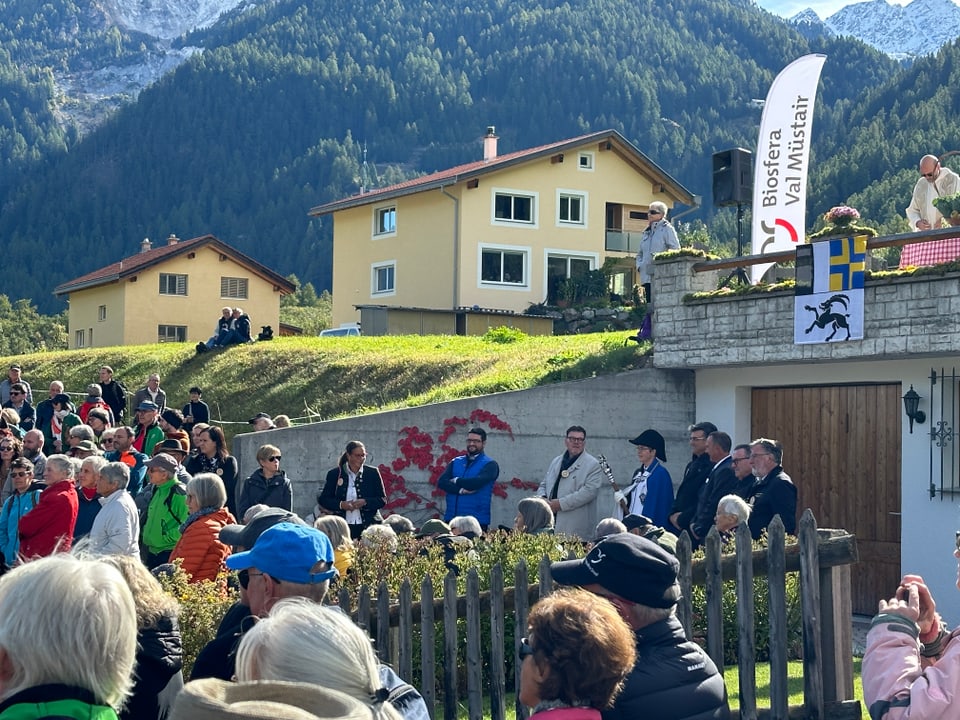 Menschenmenge bei Veranstaltung in alpiner Landschaft.