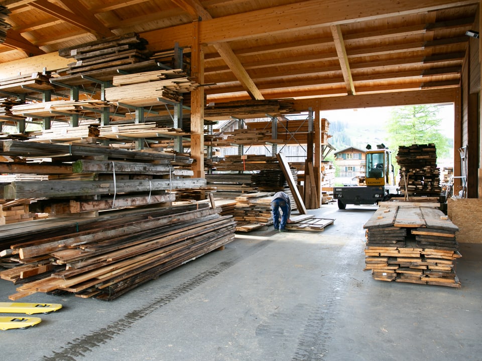 Das Holzlager der Zimmerei ist voll mit unterschieldichen Holzstücken.