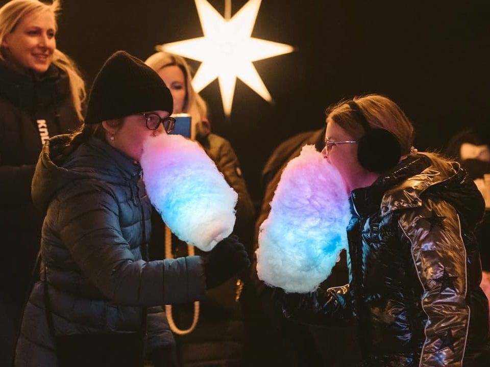 Kinder essen Zuckerwatte im Zauberpark