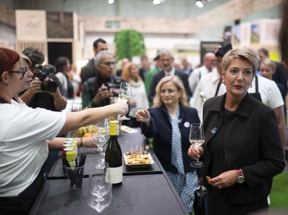 Keller-Sutter stösst an mit einem Glas Weisswein.