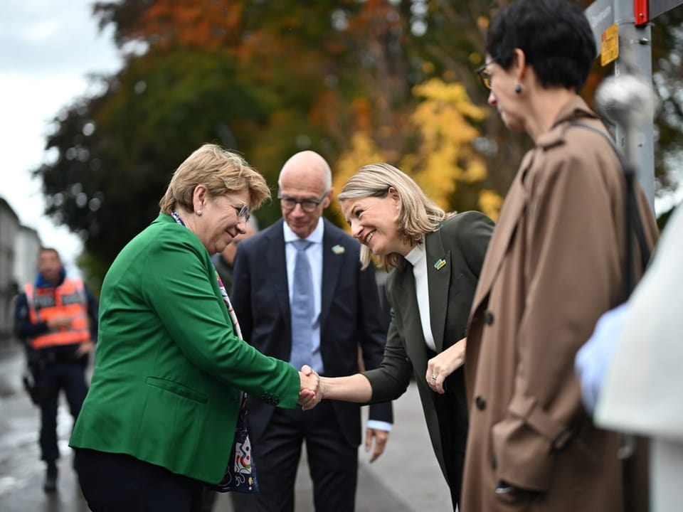 Zwei Frauen geben sich die Hand