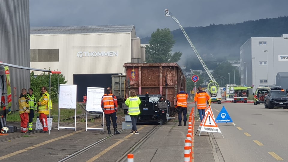 Übung von Einsatzkräften mit Feuerwehrausrüstung vor Industriegelände.