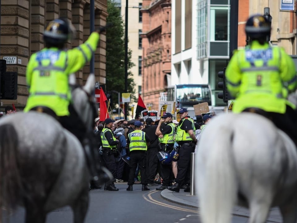 Viele Polizisten auf Pferden und zu Fuss auf den Strassen Manchesters.