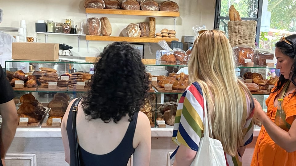 Drei Frauen stehen vor einer Bäckereitheke.