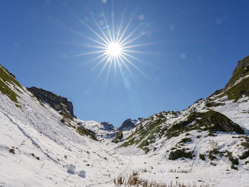 Schneebedecktes Tal mit strahlendem Sonnenschein.