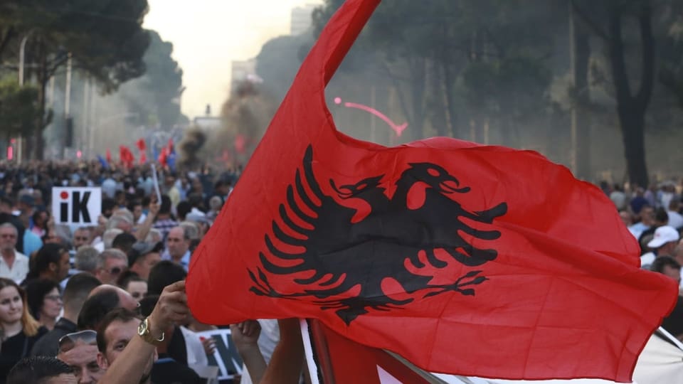 Leute mit albanischer Flagge am demonstrieren.