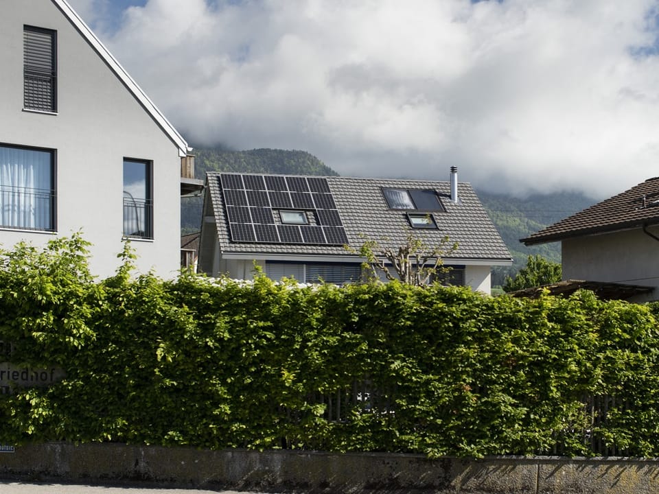 Ein Einfamilienhaus mit einer Solaranlage auf dem Dach zur Eigenproduktion von Solarstrom.