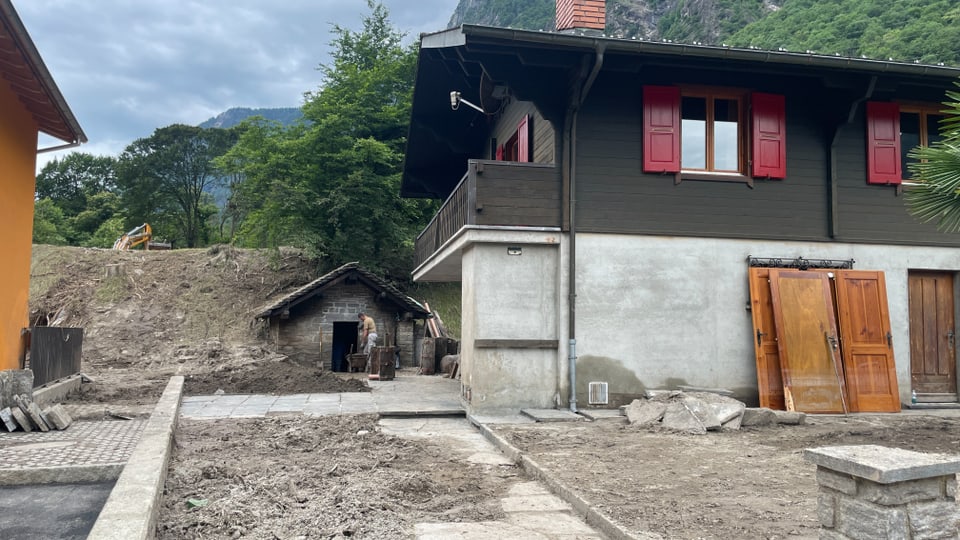 Ein Haus in Lostallo mit von Schlamm bedecketem Garten.