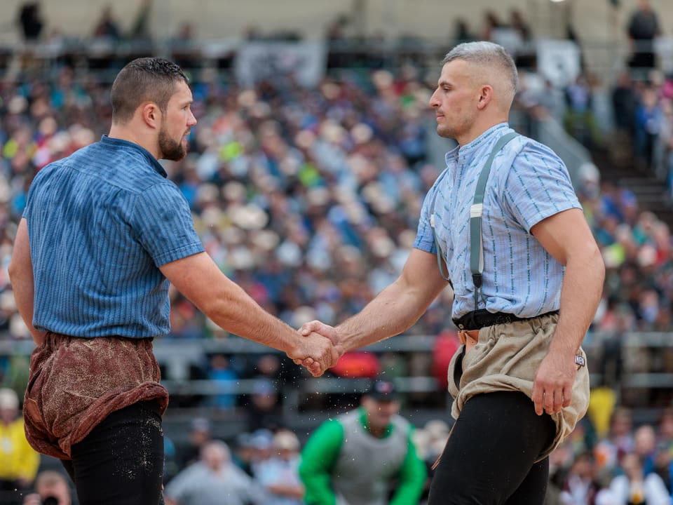 Zwei Männer im traditionellen Ringkampfwettbewerb, die sich die Hand geben.