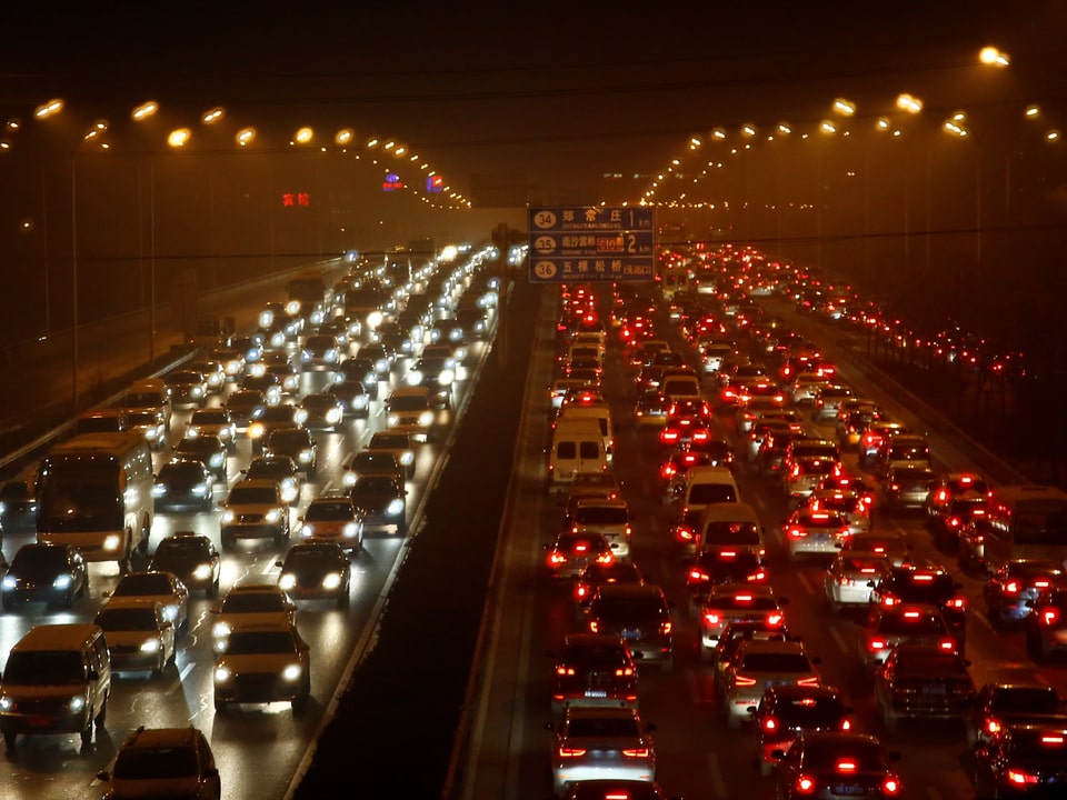 Von Smog verhüllte mehrspurige Strasse in Peking. 