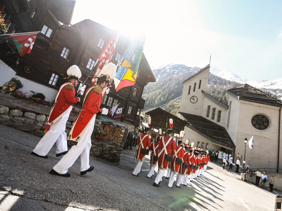 Weisse Hosen, rote Mäntel und hüte mit weissen Federn.