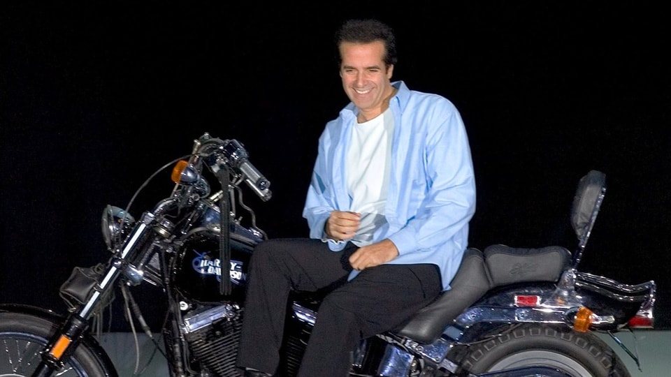 Entertainer David Copperfield sitzt auf einem Motorrad auf einer Bühne