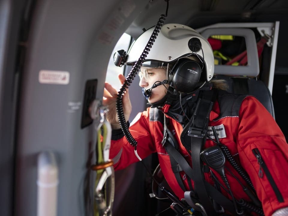 Frau in Rega-Helikopter schaut aus dem Fenster