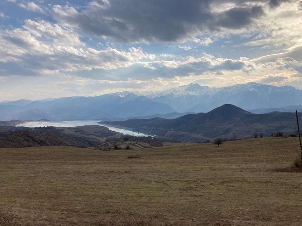 Landschaft und Wolken: Hügel und ein See