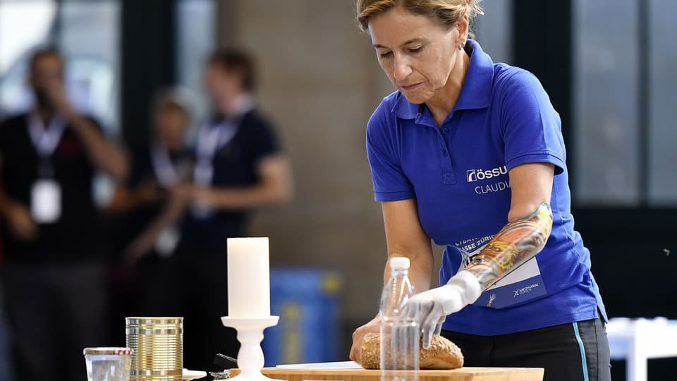 Eine Frau mit einer Lähmung am Arm schneidet ein Stück Brot.