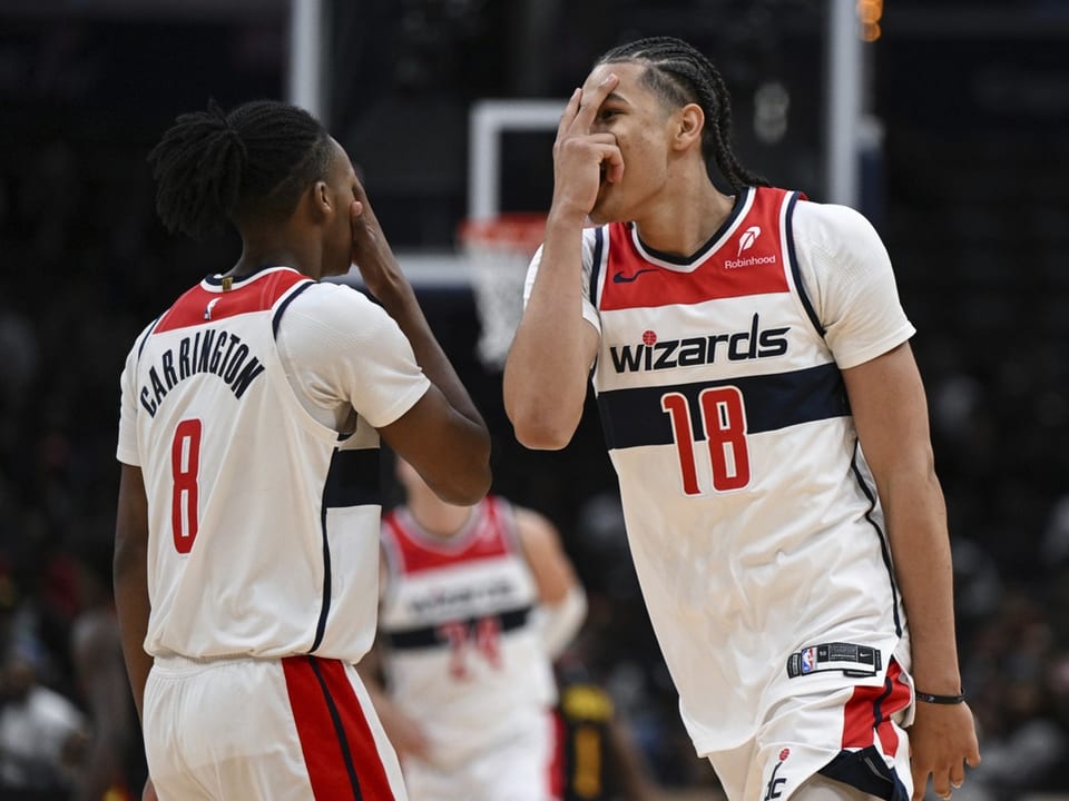 Zwei Basketballspieler der Wizards jubeln auf dem Spielfeld.