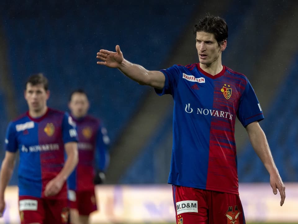 Fussballspieler in blau-rotem Trikot auf dem Spielfeld.