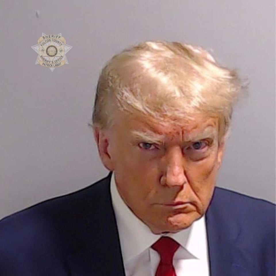 Polizeifoto des ehemaligen US-Präsidenten Donald Trump. Er blickt düster in die Kamera.