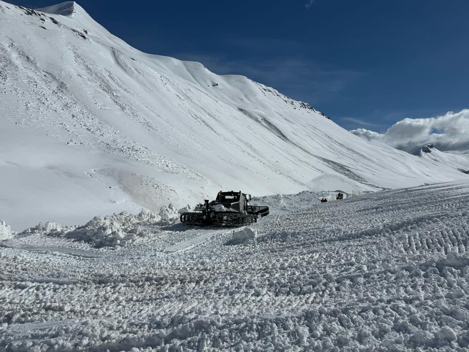 Raupenfahrzeug trägt Schnee ab