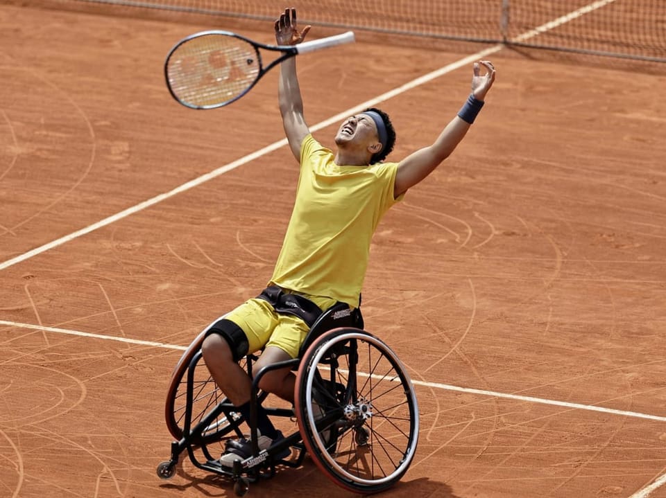 Rollstuhlfahrer feiert beim Tennisspiel.