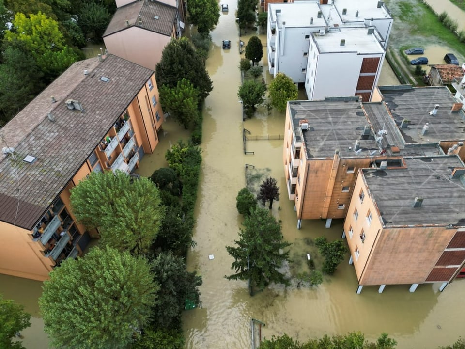 Luftbild einer überfluteten Wohngegend mit mehrstöckigen Gebäuden.