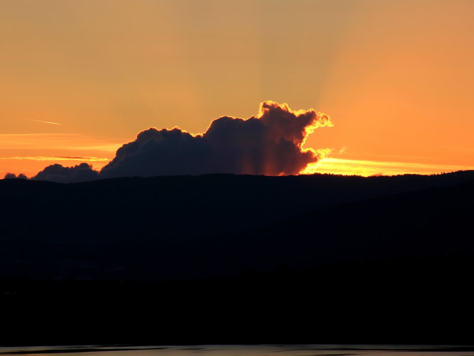 Sonne hinter den Wolken am untergehen.