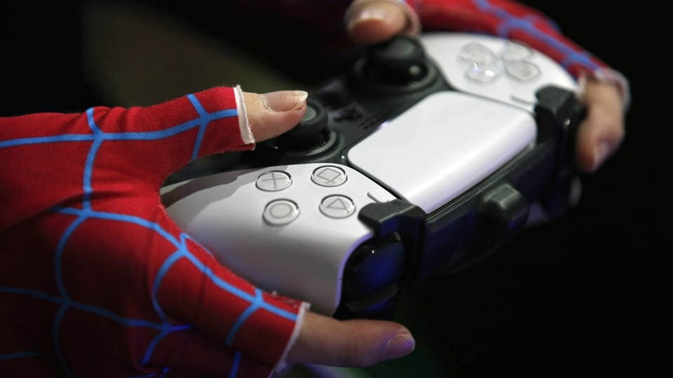 Zwei Hände halten eine Spielkonsole der Sony PlayStation 5.
